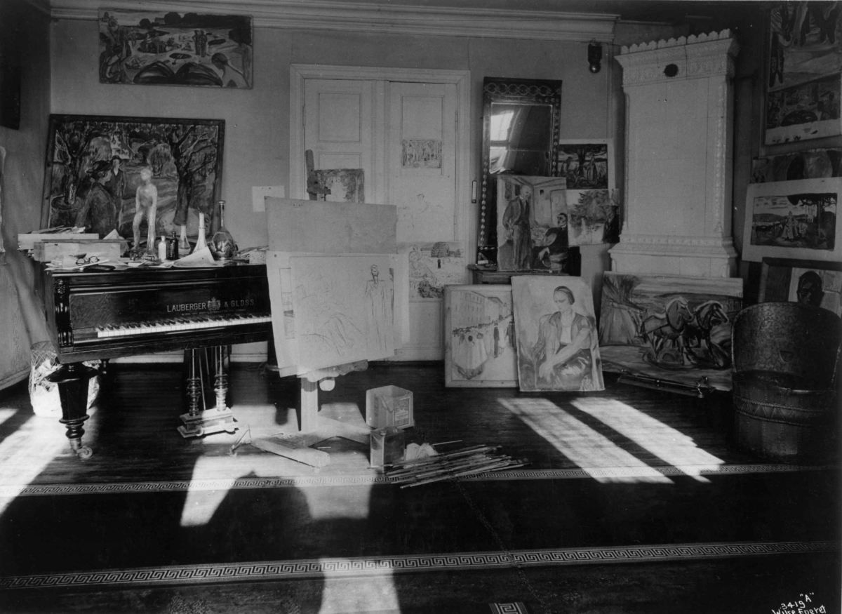 Anders Beer Wilse, Kunstneren og maleren Edvard Munch sitt hjem og atelier på Ekely i Oslo, fotografert av Anders Beer Wilse i 1937. Interiør med staffeli, malerier, flygel, kubbestol og speil.