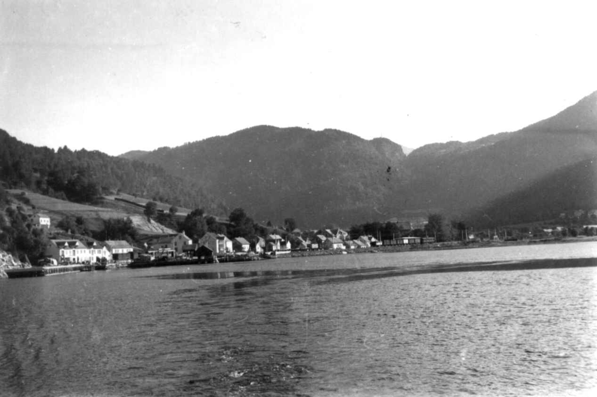 Hermann Christian Neupert, Voss 1939. Vangsvatnet med bebyggelse. Landskap med jorder. Høyonn. Skog og fjell i bakgrunnen.