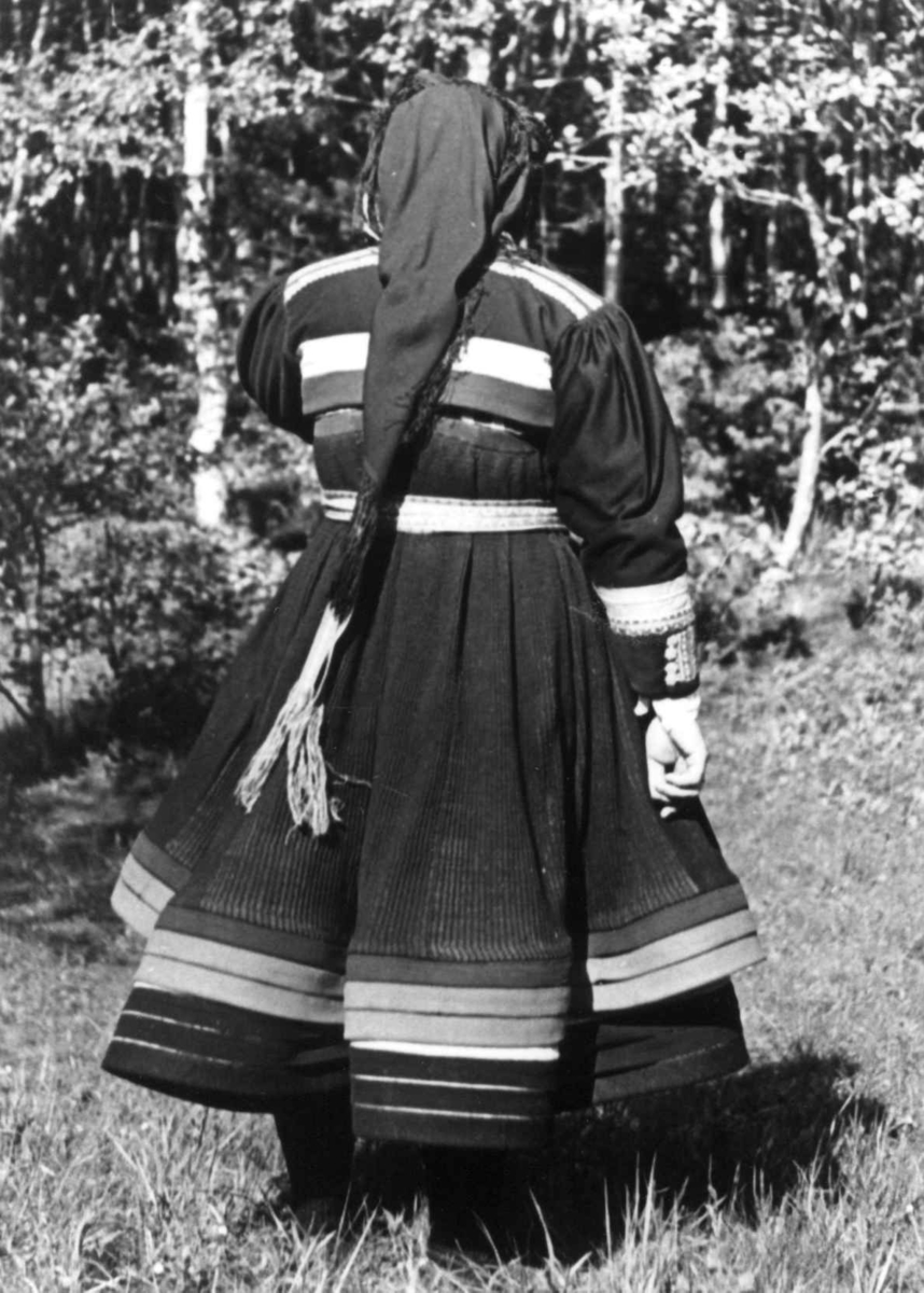 Anna Grostøl, Valle Setesdal, Aust-Agder 1939. Bondestevne. Portrett av en kvinne i bunad sett bakfra.