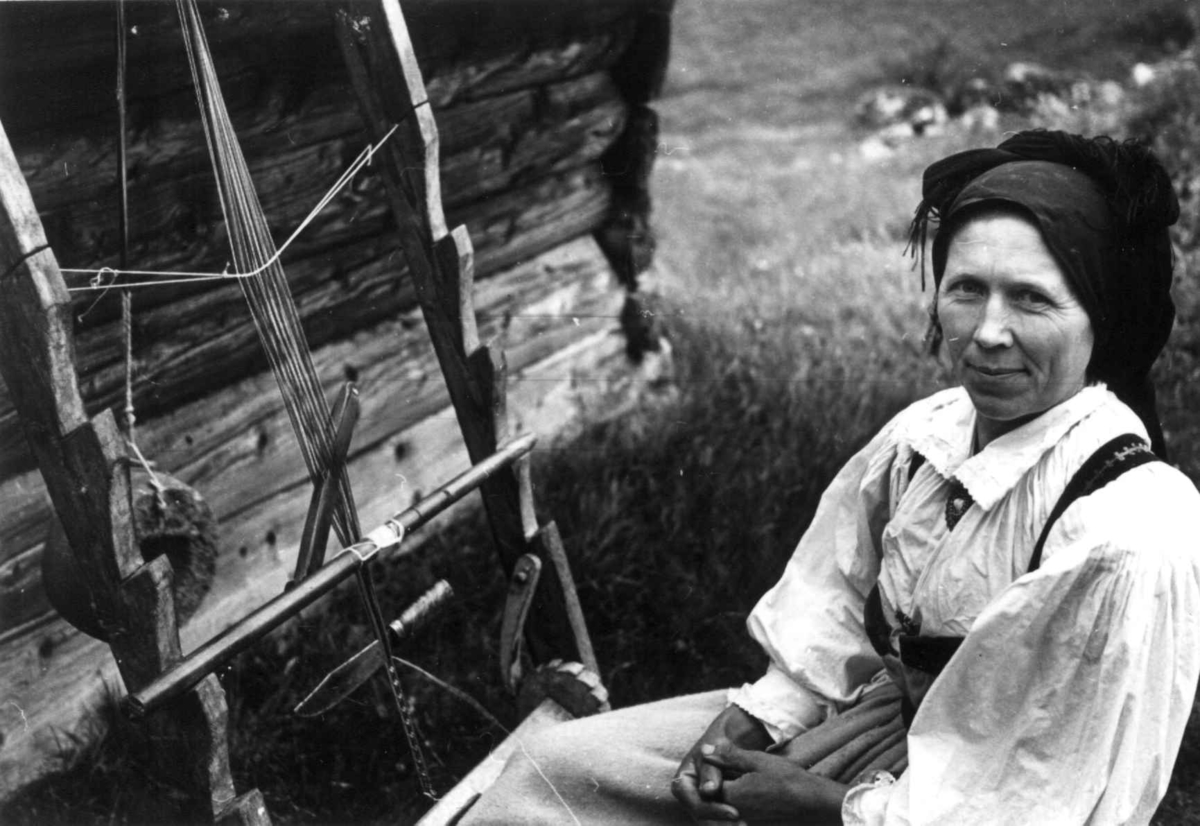 Anna Grostøl, Valle Setesdal, Aust-Agder 1939. Portrett av Eli Åmli som sitter ved båndveven.