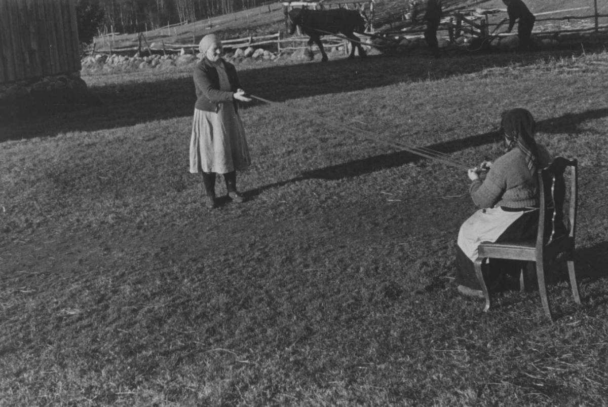 Anna Grostøl, Bondekone Kristi Espeli og datteren lager snor til å ha nederst på stakk og kjoler. Åseral, Vest-Agder 1943.