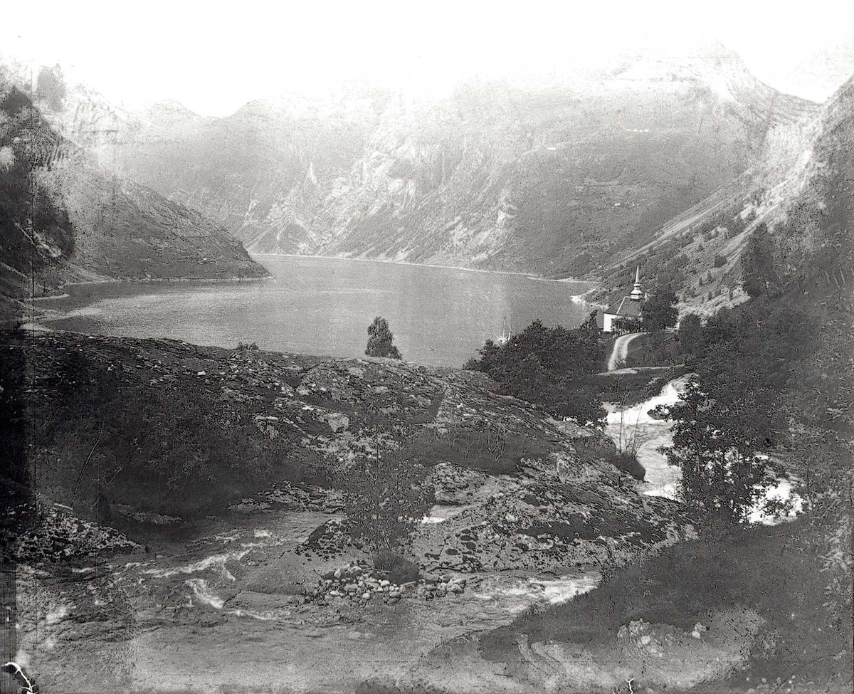 Tom Kent, Stranda, Geiranger. Mot fjorden, kirke ligger til høyre.