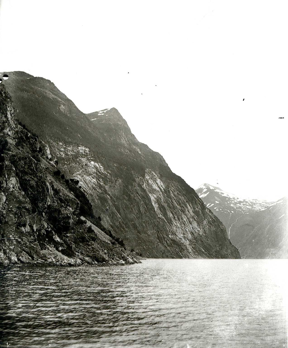 Tom Kent, Bilde tatt fra sjøen mot bratte fjell og fjord.