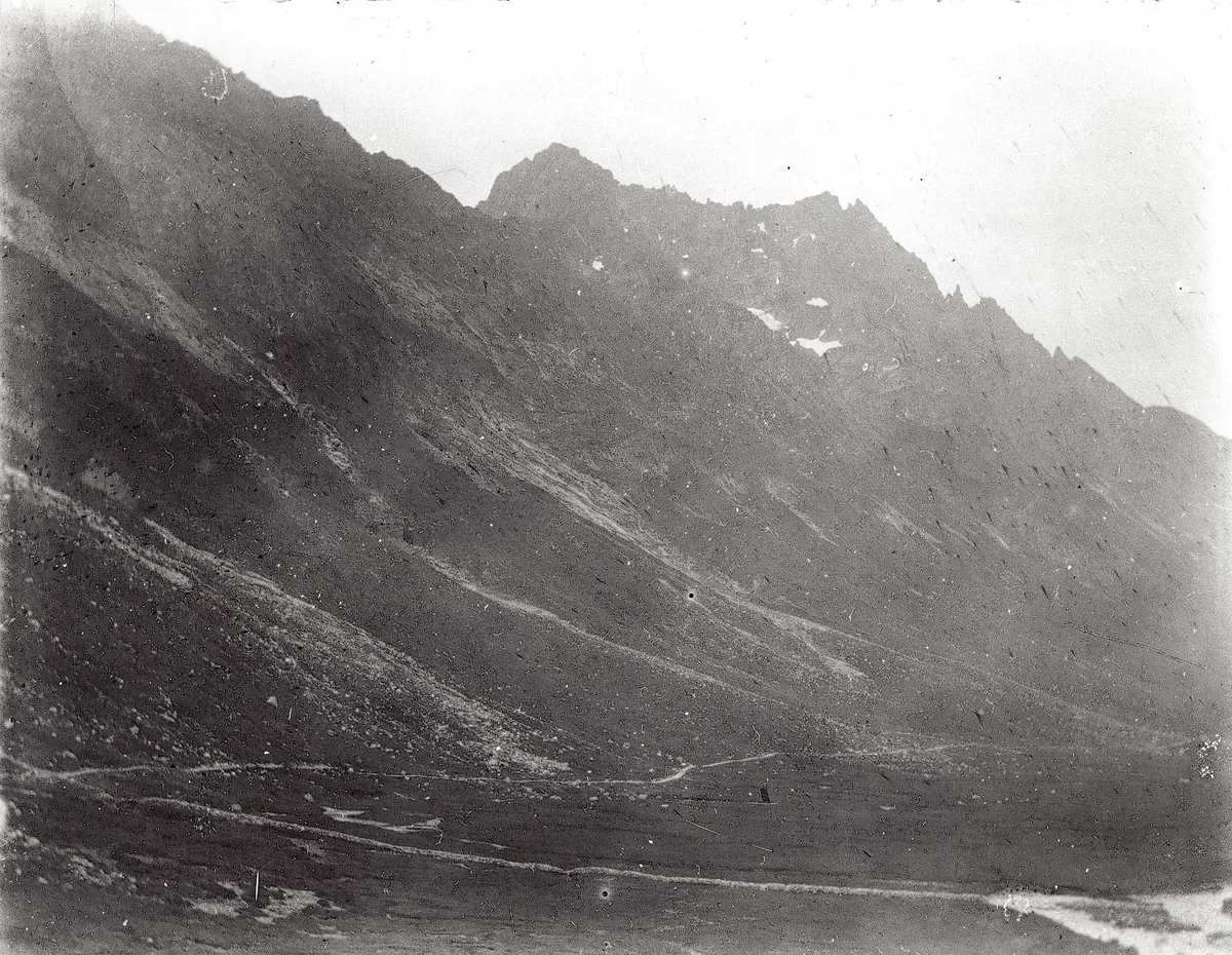 Tom Kent, Fjelldal med stier under bratt fjell.