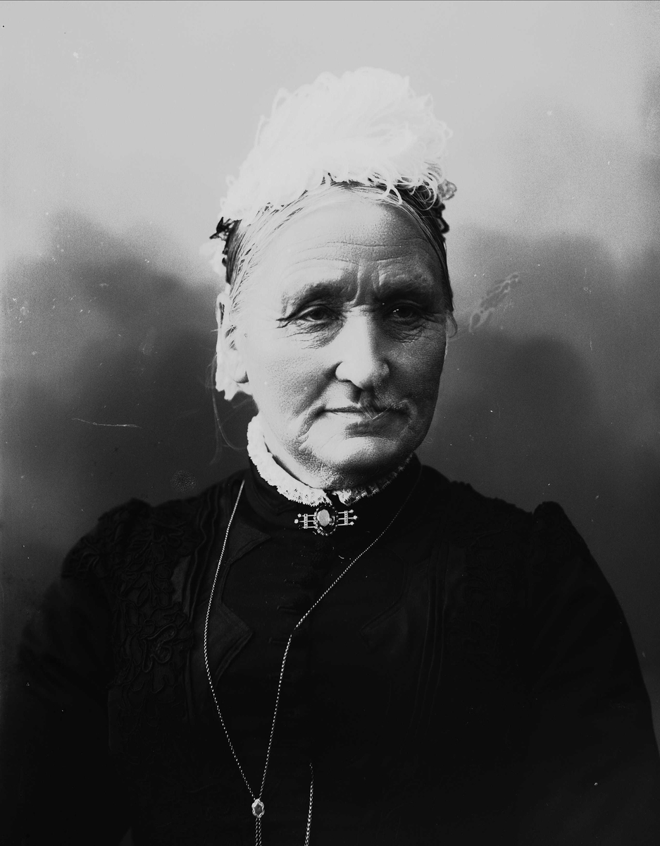 Solveig Lund, Brystportrett av eldre kvinne med kjole, brosje og halssmykke.