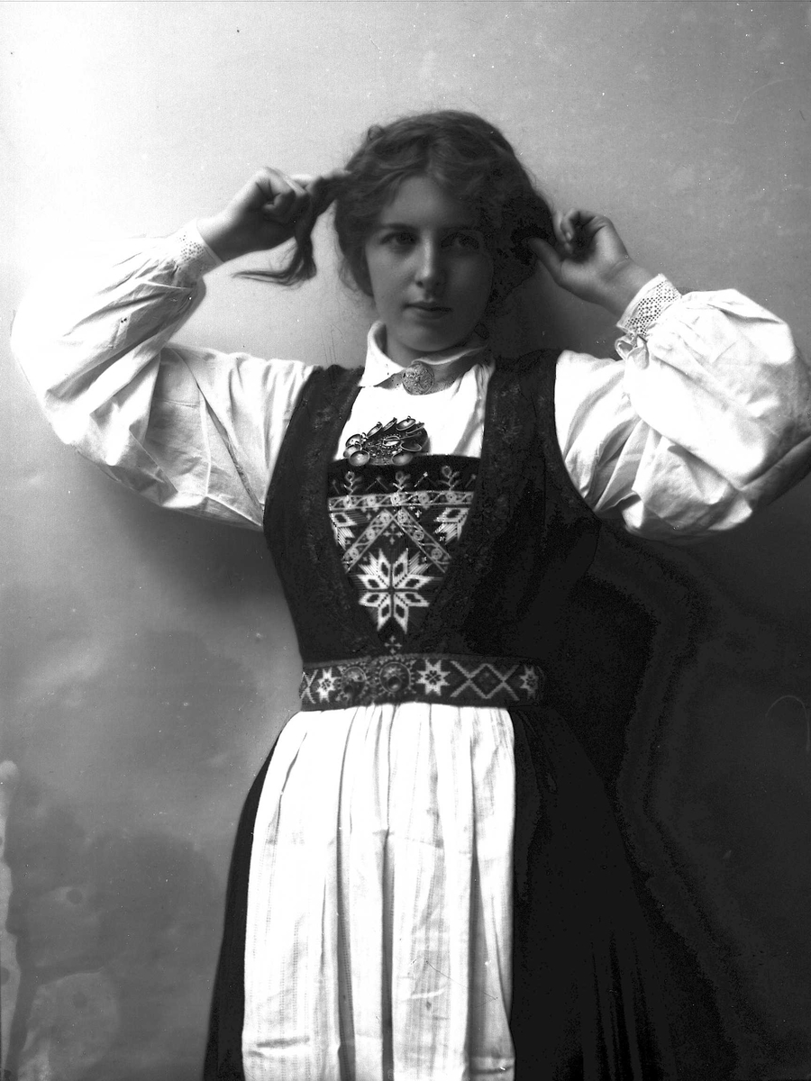 Solveig Lund, Studioportrett av kvinne i drakt som tar seg i håret.