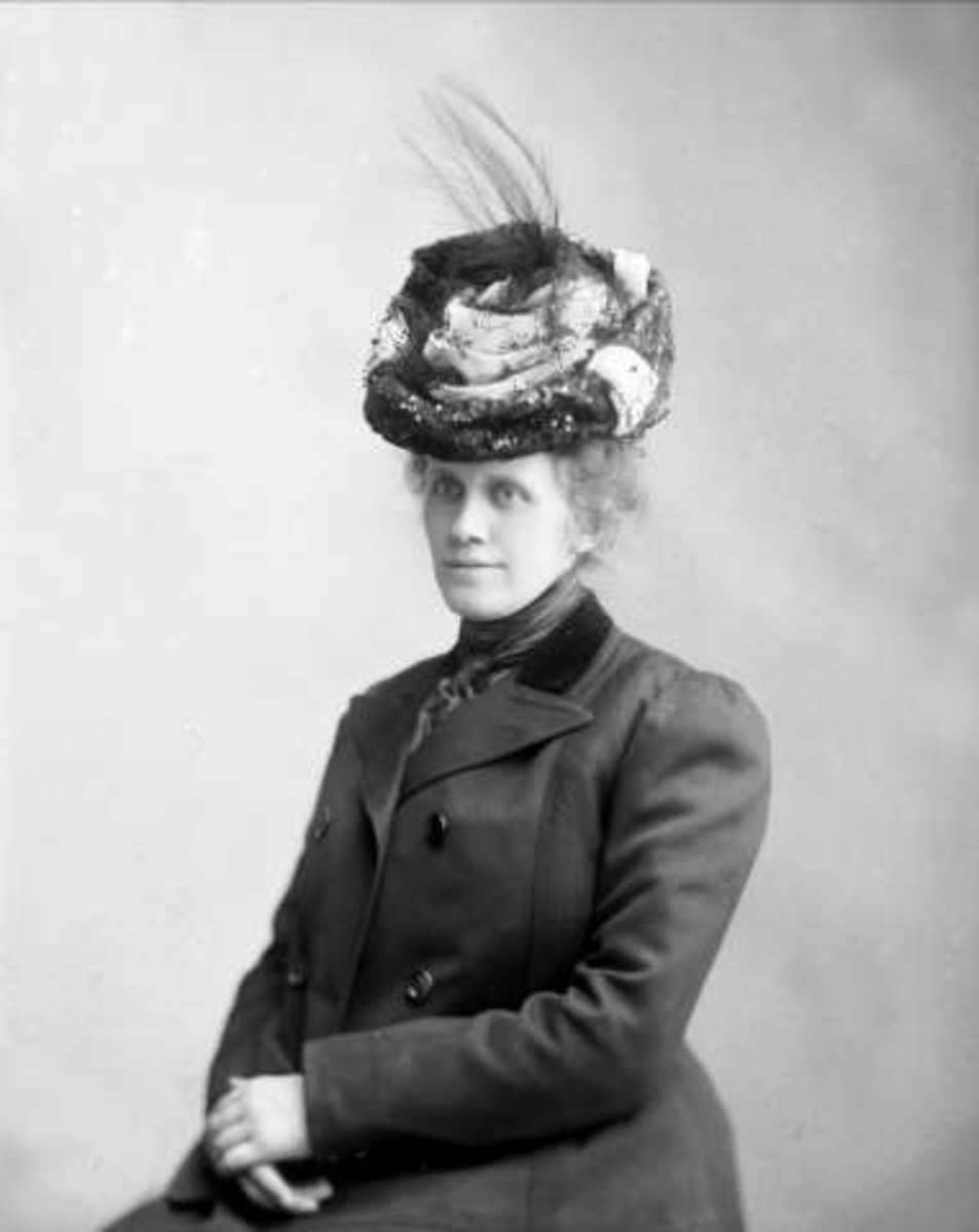Gustav Borgen, Portrett, kvinne i mørke ytterklær med hatt. Fru Erikka Mathisen.