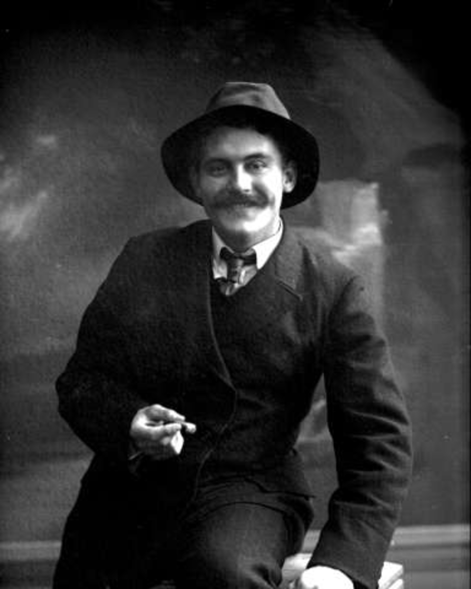 Gustav Borgen, Portrett, smilende mann med dress, hatt, sigar og bart. Herr Kristiansen.