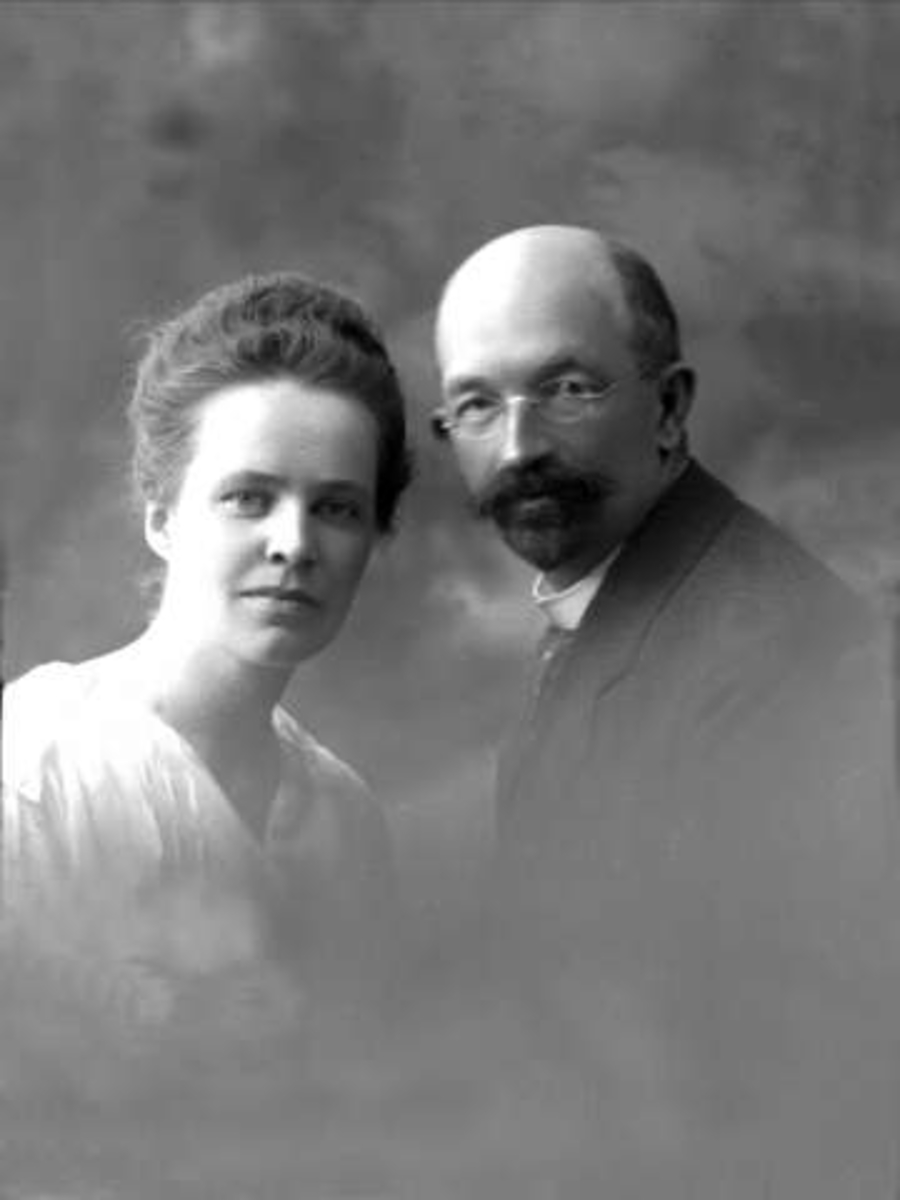 Gustav Borgen, Gruppeportrett, ektepar, lys drakt og dress. Briller og skjegg. Avdelingssjef Horgen.