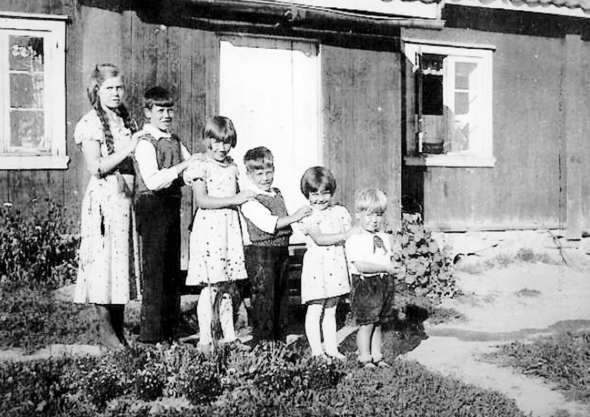 Ukjent, "Tullemor" Inger Marie Johansen, Eskild Johansen, "Lillesøster" Margrethe Johansen, "Vesle" Ragnvald Johansen, Liv Kaspara Johansen og John Johansen. Bodde på husmannsplassen Rolig, unna Børstad.