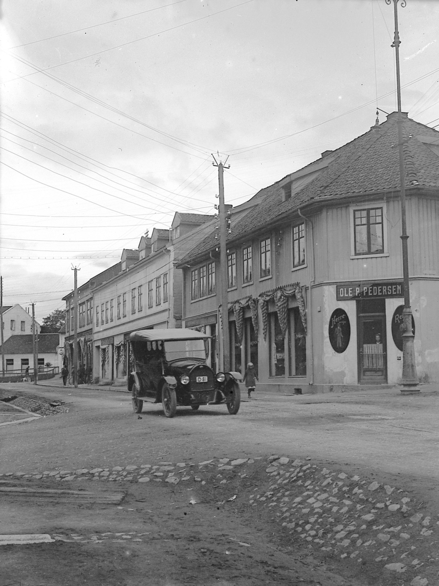 Ragnvald Andersen, Gatebilde, Ole P Pedersens skredderforretning i Torggata 51 i Hamar, bil i gata. D-81.
