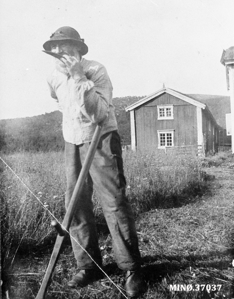 Ukjent, Holden ca. 1915 - Esten Holden kvesser ljåen