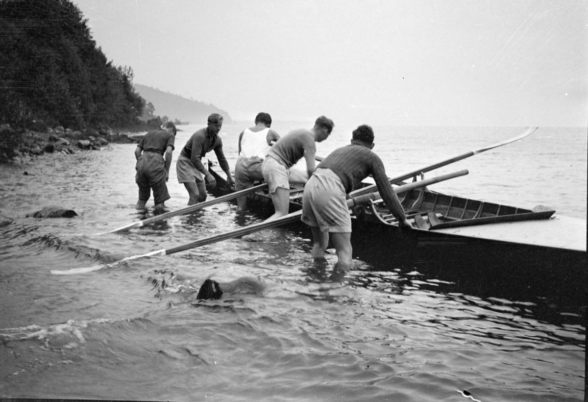 Johs. (Johannes) Johannessen, Robåt settes på vannet, firer med styrmann, medlemmer av Hamar roklubb, Mjøsa, Jessnes.