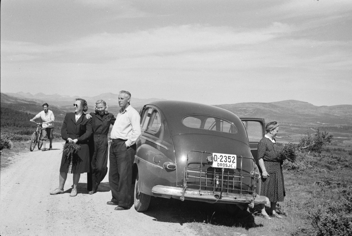 Johs. (Johannes) Johannessen, Biltur, utflukt, fjelltur, drosje D-2352. Ford 1946-47 eier Paul Wang, Solvang, Hamar. Eiere iht "Hvem eier bilen" 1948. Fra høyre står Aagot Johannessen, jenta mellom paret ved bilen er Lumi Johannessen.