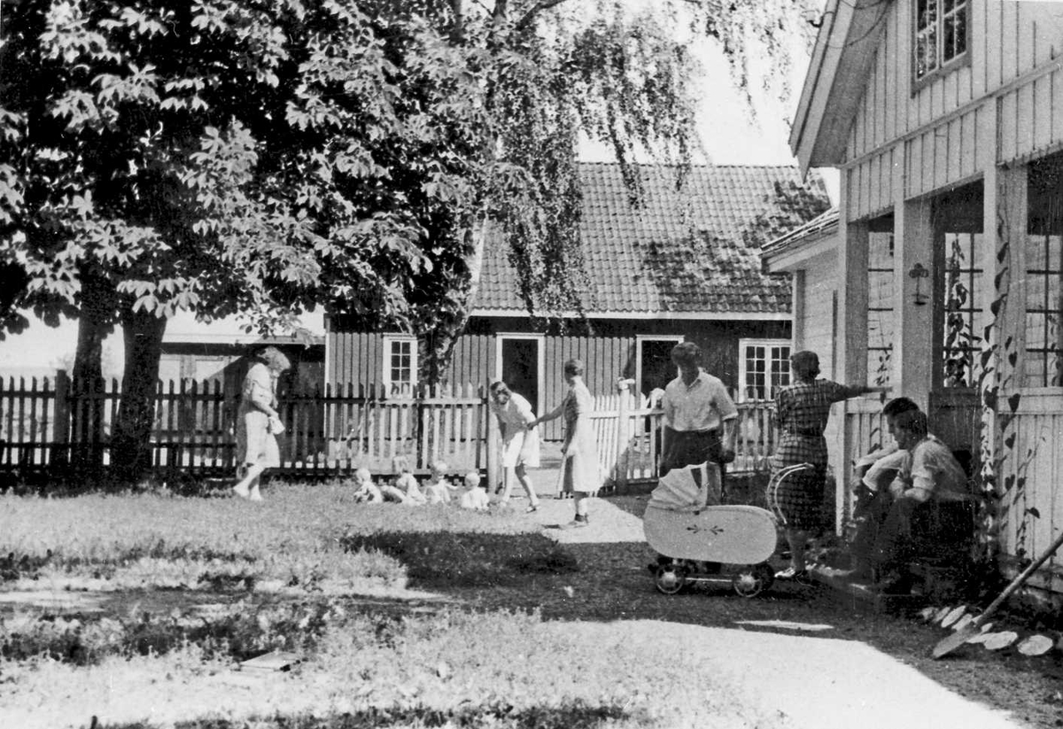 Rachel Haarseth, Bygninger, personer, klær, barnevogn, gjerde.