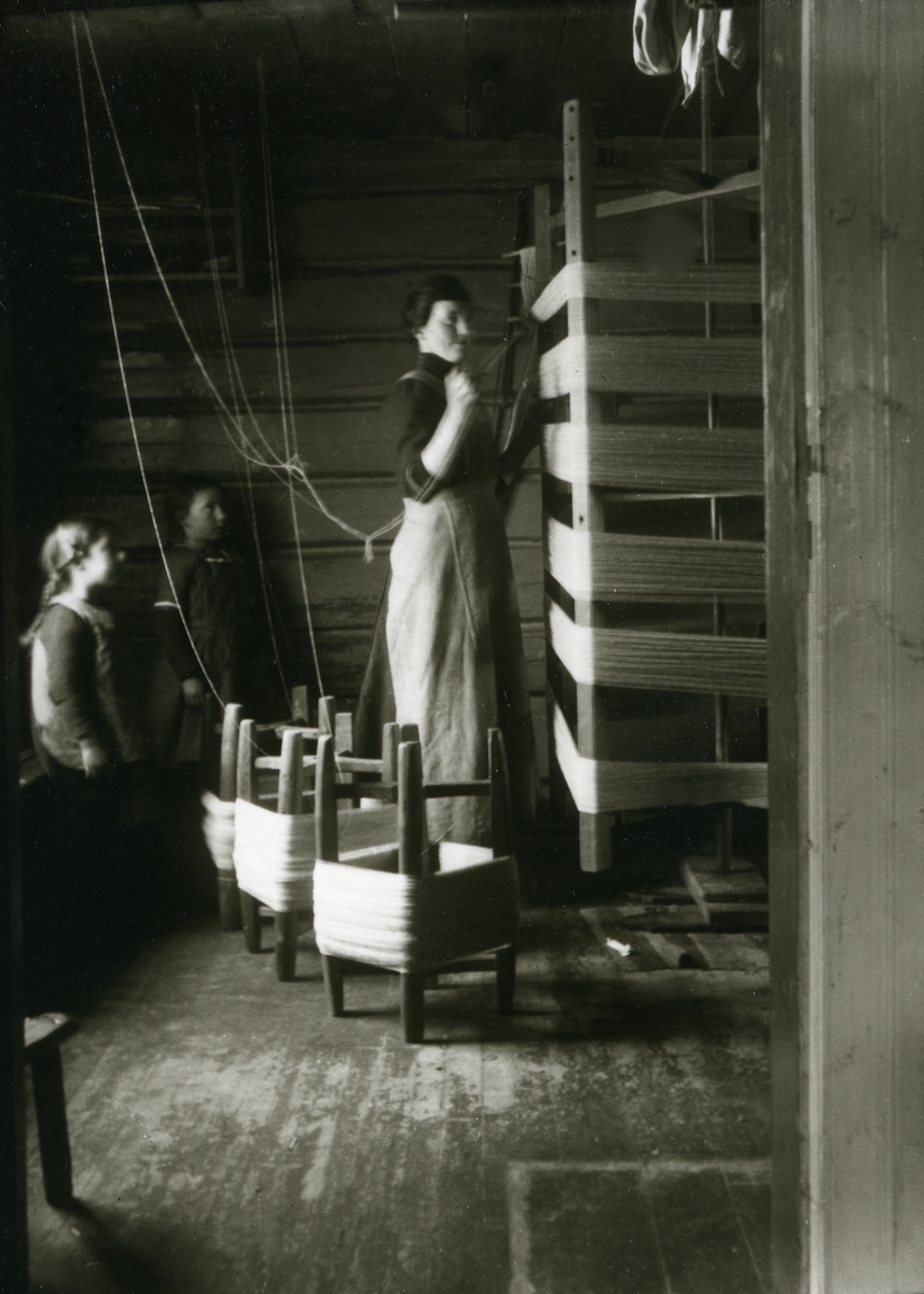 Haakon Garaasen, Kvinne i arbeid, Jenny Galaasen f. Landsjøaasen, Jons (2/3 1890 - 1983) To jenter ser på; Maalfrid Galaasen g. Hauge (21/2 1914) og Ingebjørg Galaasen g. Buflod, Jons (19/5 1915 - 1999) På Jons, Galåsen.