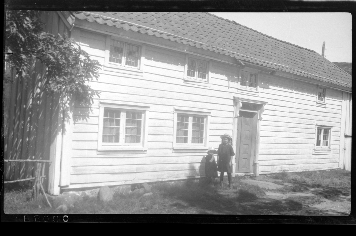 Rolf Sr. Sundt, To ukjente barn står ved et hus i 1923.