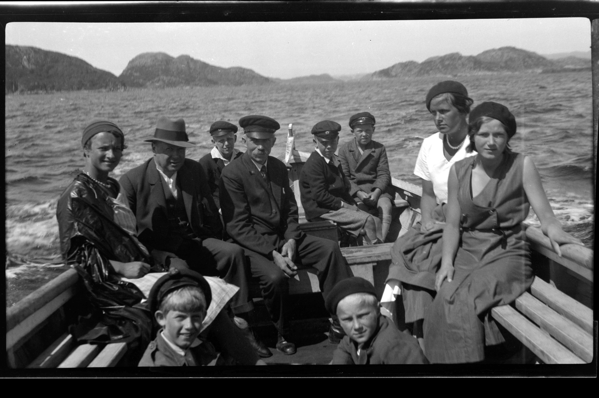 Rolf Sr. Sundt, Lillemor Nickelsen, Finn Sundt, Ole, Olav, Eilert og John Olsen, Lise Skabo, Mossi og John Arne Lund Tønnessen og Rolf Sundt jr. sitter i en båt ved Ullerø i Farsund.
