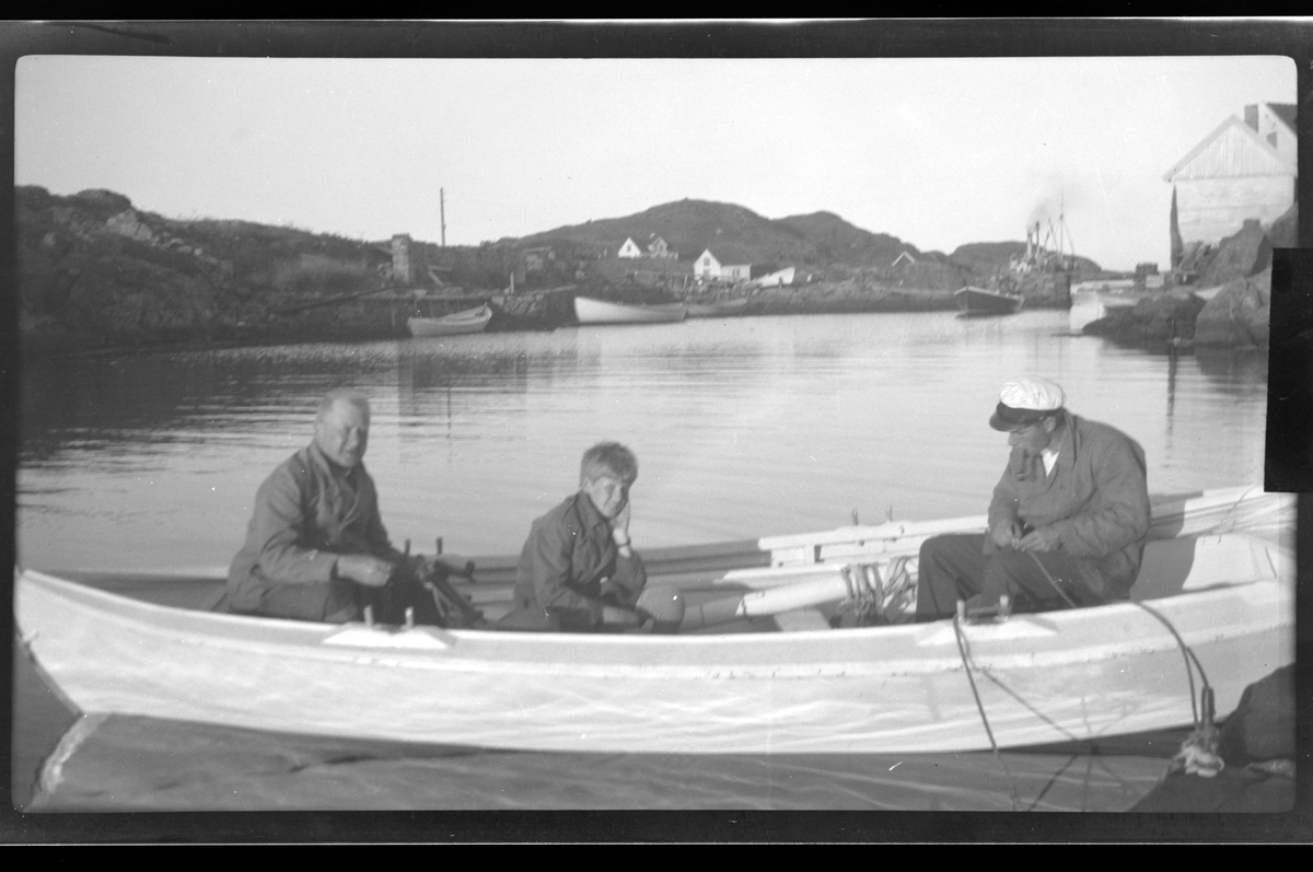 Rolf Sr. Sundt, Finn Sundt, Rolf Sundt jr. og Erling Rune sitter i en robåt mellom Holmen og hytten Rune i Farsund.