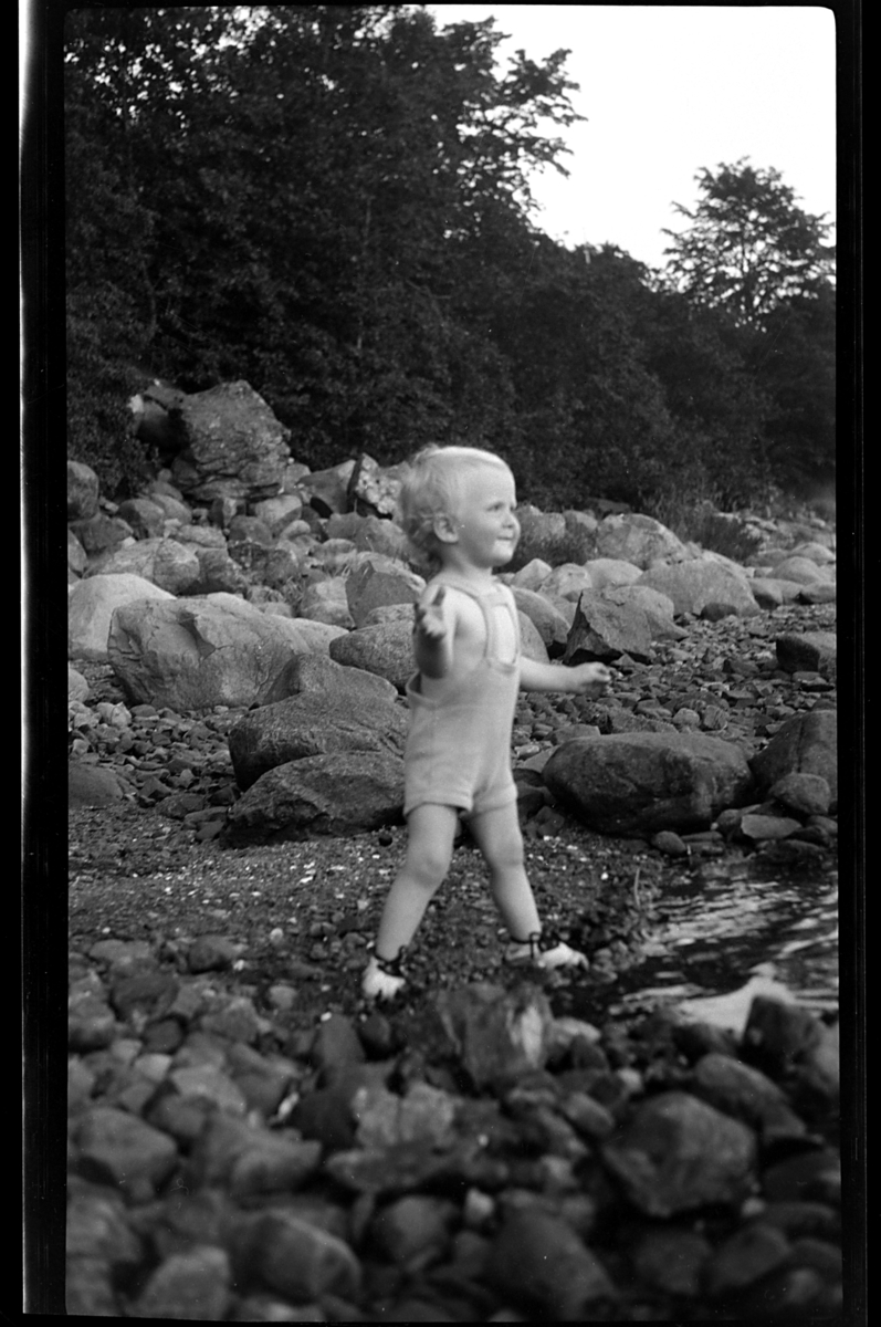 Rolf Sr. Sundt, Lars Peter Sundt kaster sten på stranden ved Flaskebekk på Nesodden. Fotografert 1931.