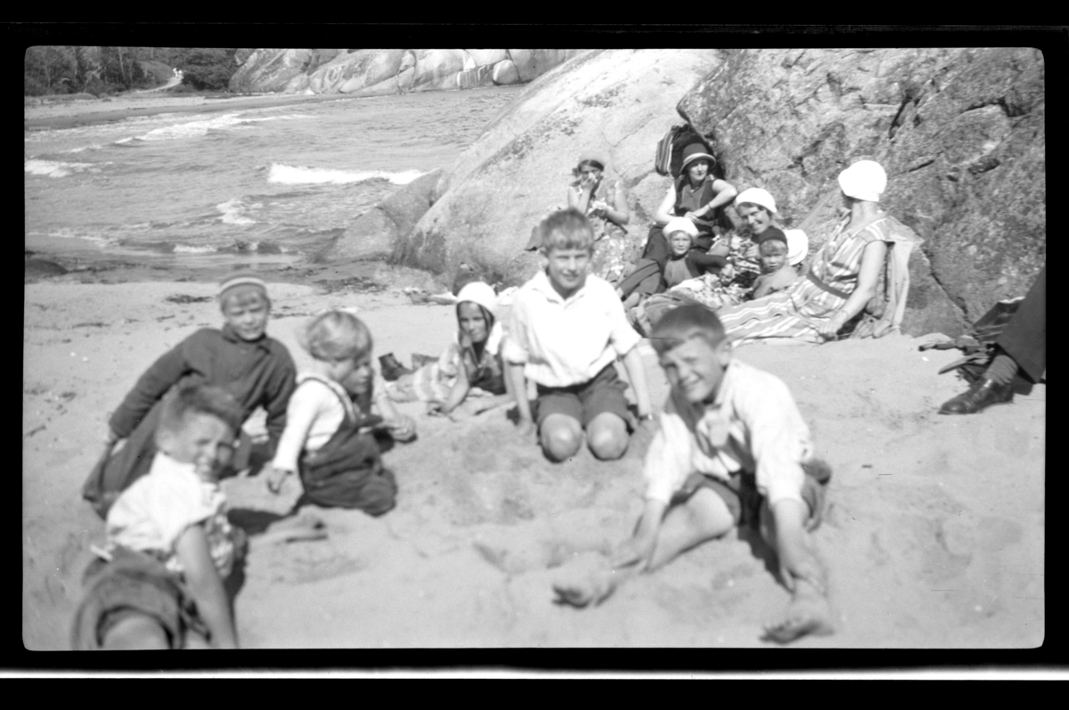 Rolf Sr. Sundt, Strandliv ved Ula i Vestfold. Bak ved svaberget fra venstre ukjent kvinne, Hilda Sundt, Elisabeth Hansen, Betsy Aubert Hansen, Sven og Lilly Moestue. Foran Arne Moestue, Lars Peter og Rolf Sundt Jr. med lokale lekekamerater. Fotografert 1932.