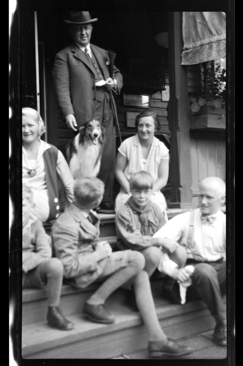 Rolf Sr. Sundt, Gruppe av voksne og barn fotografert på trapp. Fra venstre Rolf Jr., Cecilie (Essemor), Finn og Julius, alle Sundt, Einar Aubert Hansen samt to kvinne og mann. Fotografert 1928.