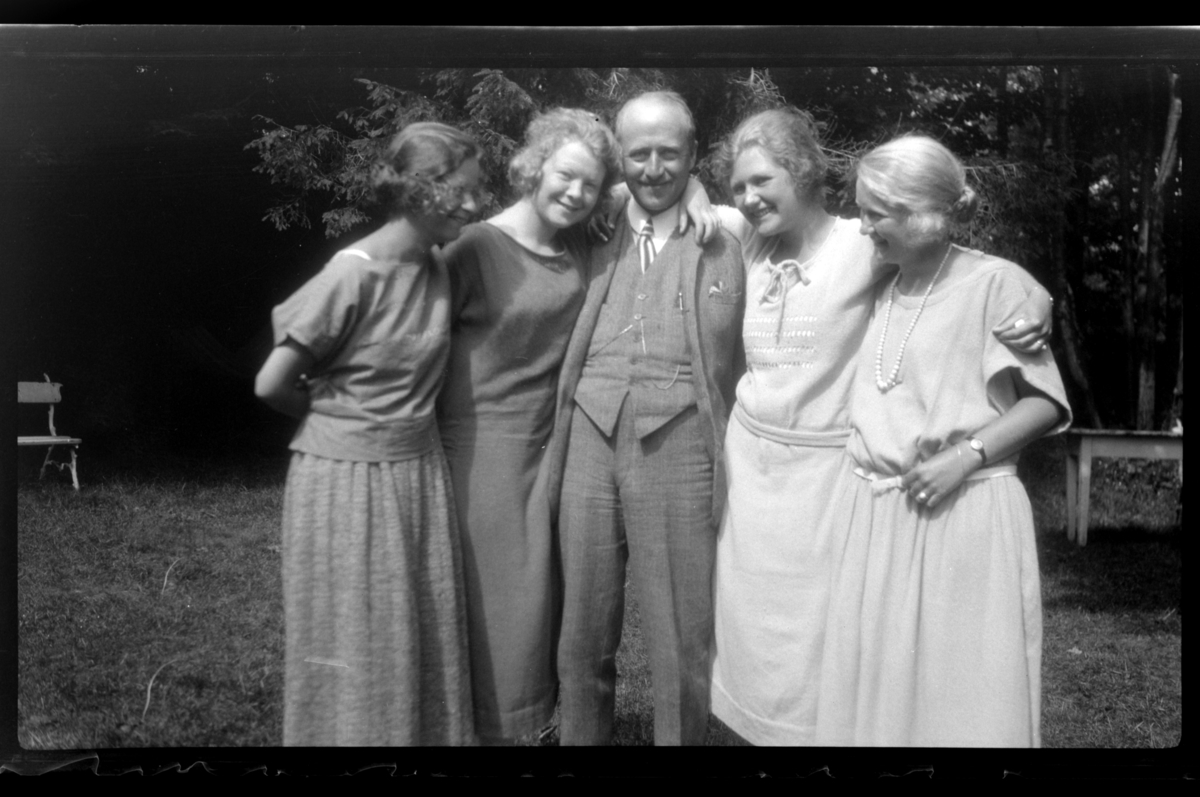 Rolf Sr. Sundt, Else Juell, Allis Anker Sundt, Rolf Sundt sr., Evie Sundt og Cecilie (Essemor) Sundt står sammen i en hage, Stavern. Fotografert 1923.