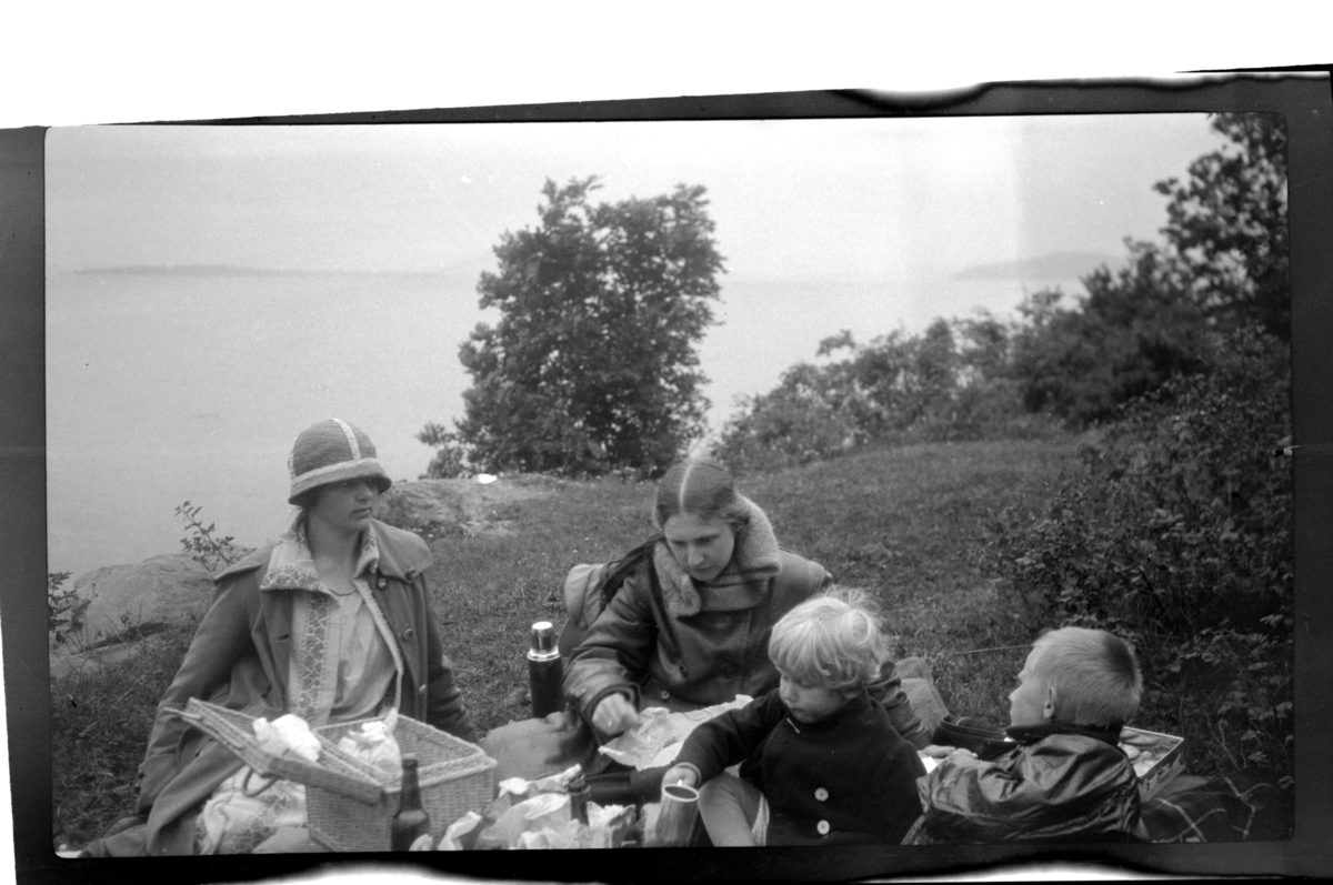 Rolf Sr. Sundt, Hilda Sundt og sønnene Rolf Jr. og Julius på picnic ved kysten. Ukjent kvinne til venstre. Fotografert 1925.