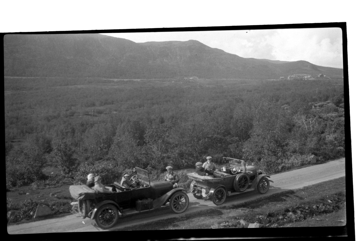 Rolf Sr. Sundt, To biler med passasjerer raster på ukjent høyfjell. I midten Hilda Sundt ved rattet og Rolf Sundt Sr. foran bilen. Fotografert 1925.