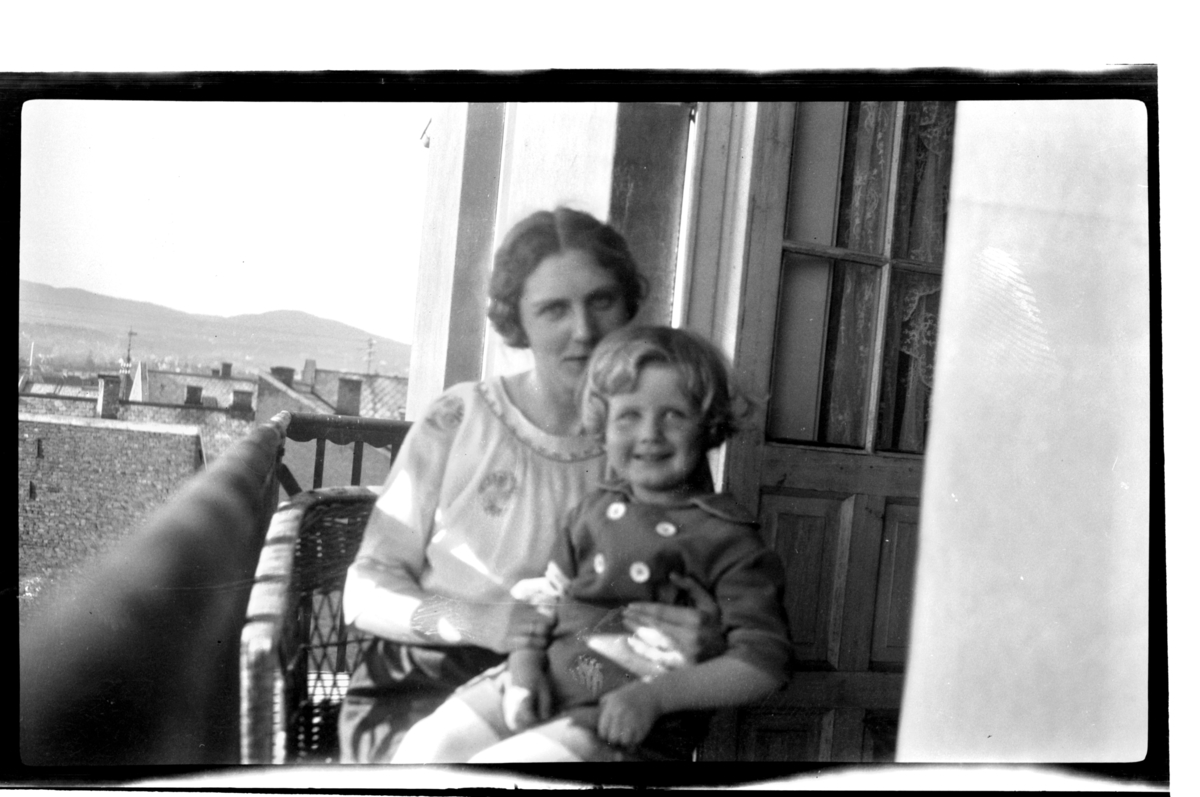 Rolf Sr. Sundt, Hilda Sundt og sønnen Rolf Jr. på balkong i Thomas Heftyes gate 42E i Oslo. Utsikt over Oslos tak. Fotografert 1925.