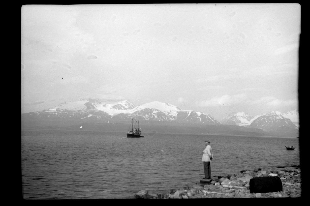 Rolf Sr. Sundt, Rolf Sundt Sr. ved vannkanten i kystlandskap med snødekte fjell, under en tur med Hurtigruten.