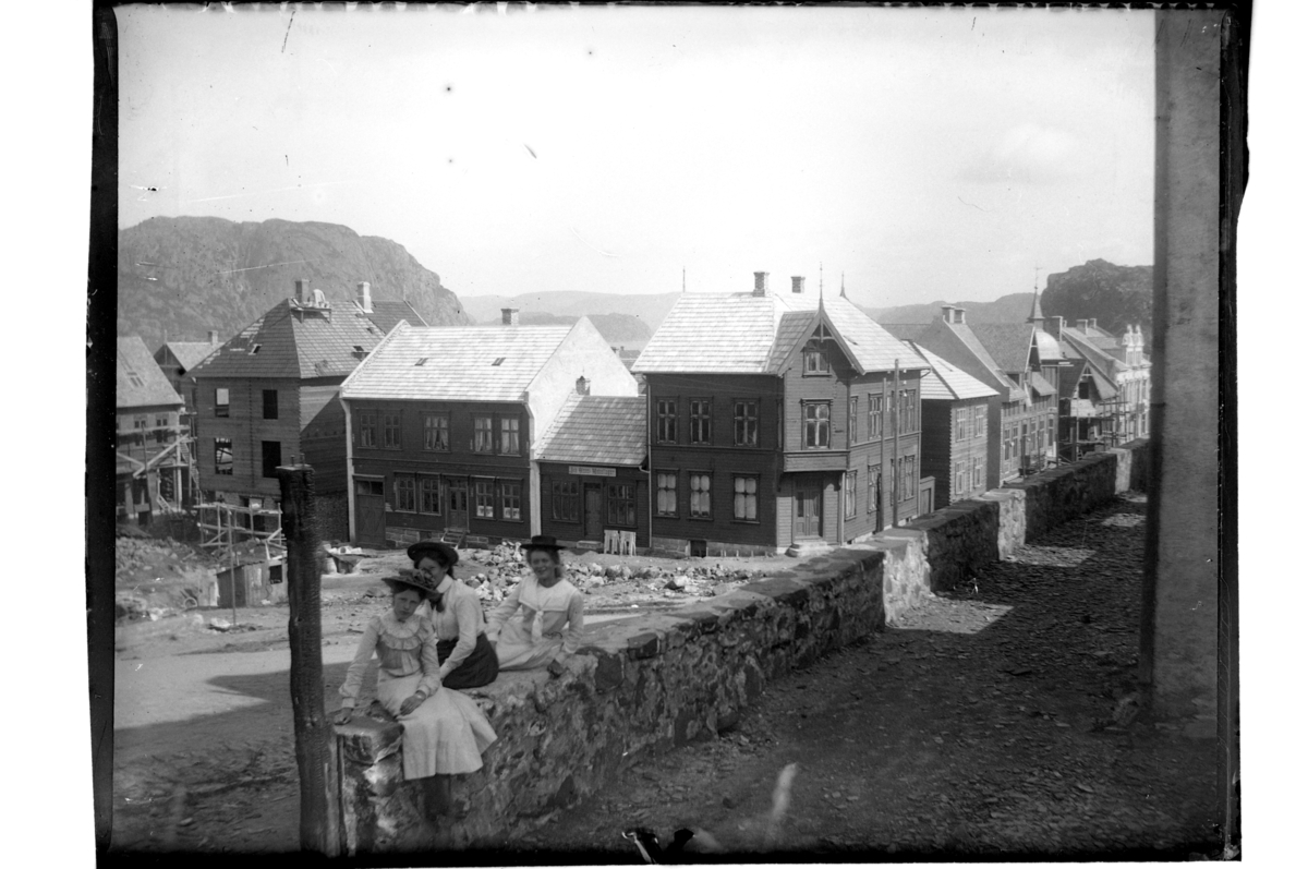 Rolf Sr. Sundt, Tre unge jenter foran kirkeruinen, etter bybrannen 1901, mot Nytorvet i Farsund. Fra venstre ukjent, Tiljen Thurmann-Andersen og Plata Atlanta Buch. Fotografert 1903.