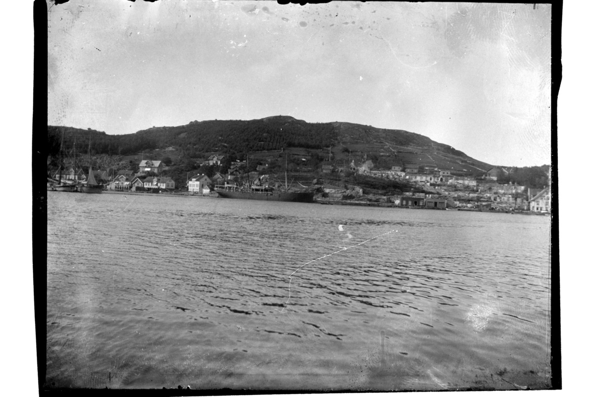 Rolf Sr. Sundt, Utsikt fra sjøen mot Svinehagen etter bybrannen i Farsund. Et forsyningsskip ligger ved kai. Fotografert 1901.