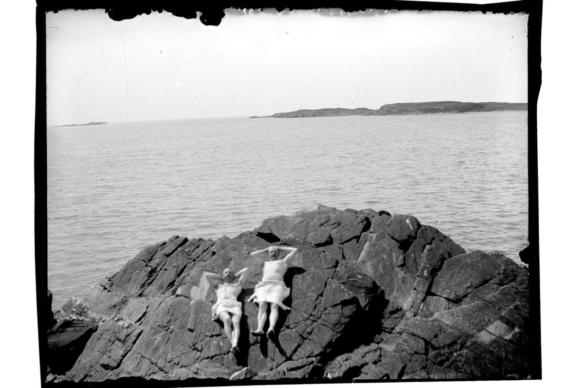 Rolf Sr. Sundt, To ukjente menn soler seg på svaberg, antagelig i Farsund-området.