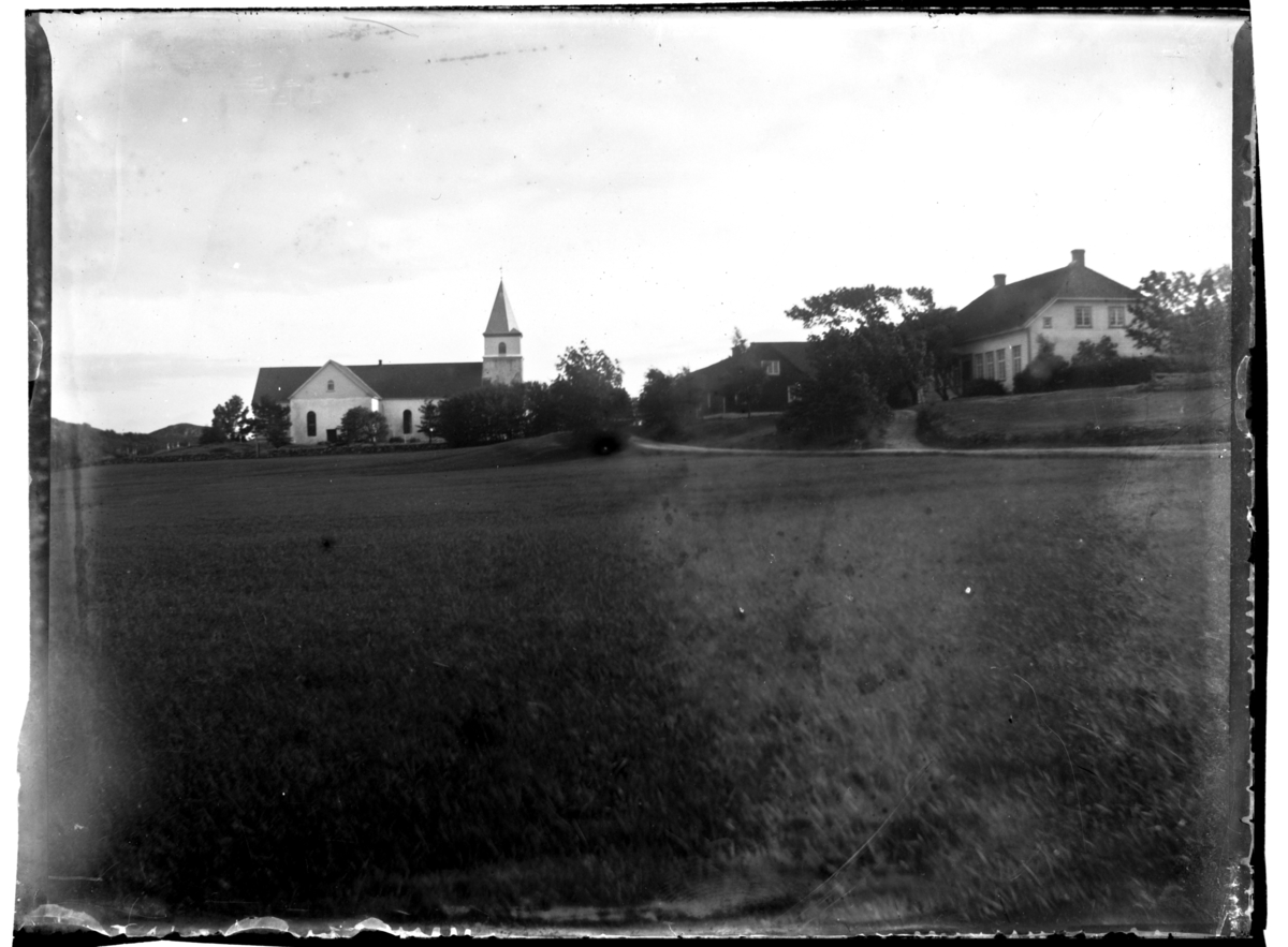 Rolf Sr. Sundt, Vanse kirke, Farsund. Ukjente bygninger ligger ved siden av. Fotografert ca. 1903.
