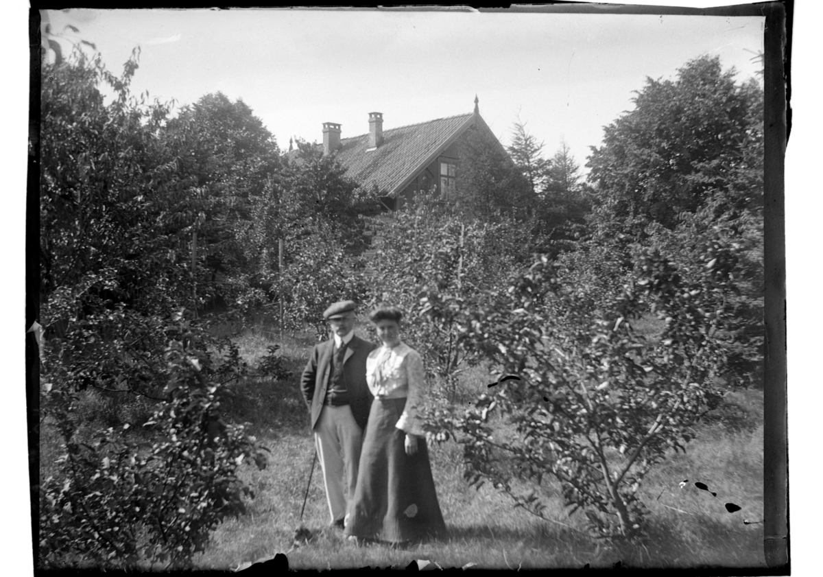 Rolf Sr. Sundt, Trygve Sundt står med sin frue Elisabeth i hagen på Farøy. Fotografert 1903-1904.