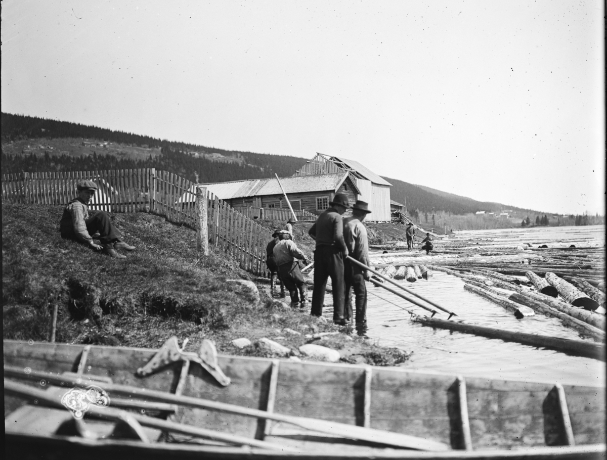 Otto W. F. Mejlænder, Trysilelva, fløting, tømmer, I bakgrunnen Bjønns(Sørhus) og Saga, Gunder-saga. Fløterbåt i forkant på elvebredden.