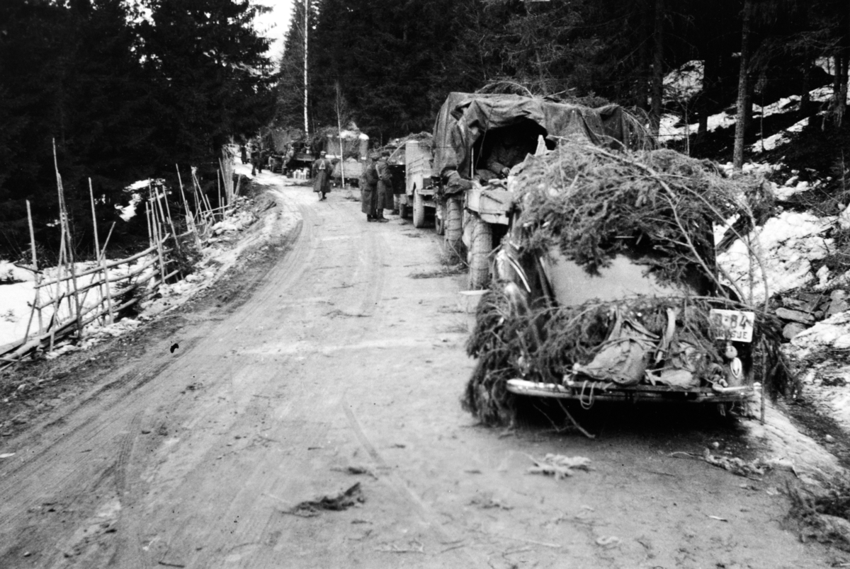 Anno Domkirkeodden, Kamuflert militærkolonne, noske soldater, på bygdeveg, trolig fra Åsmarka i Ringsaker, aprildagene 1940, Signe Lier fra Nes var med som lotte og lagde mat for soldatene. Drosje D-84 er en Ford 1939-modell. Krigen i Ringsaker.