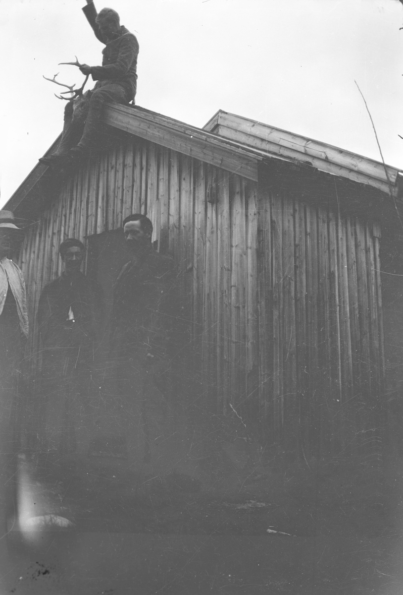 Anders O. Sørhuus, Menn foran bygning, enn mann på taket