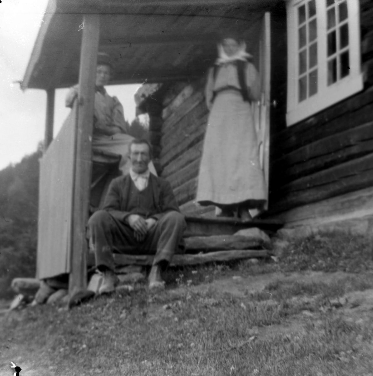 Anders O. Sørhuus, Mann og to kvinner foran hytte (Ormholet)