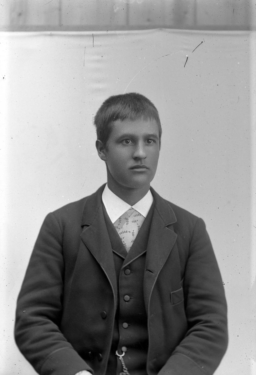 Jakob Jakobsen Engerdal, Ung mann i mørk dress og mønstret skjorte.