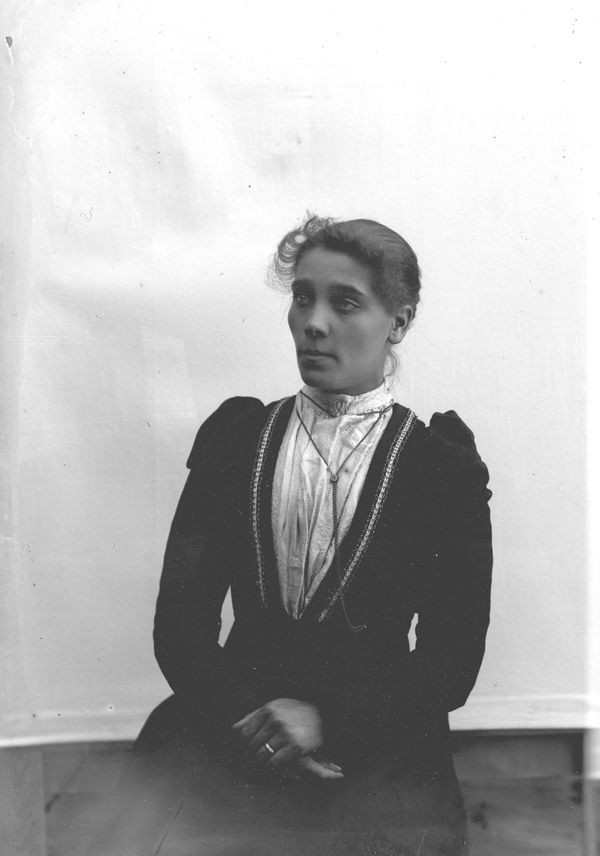 Jakob Jakobsen Engerdal, Dame i mørk drakt, hvit bluse, kjede. Gunhild Storsveen f. Pernup.