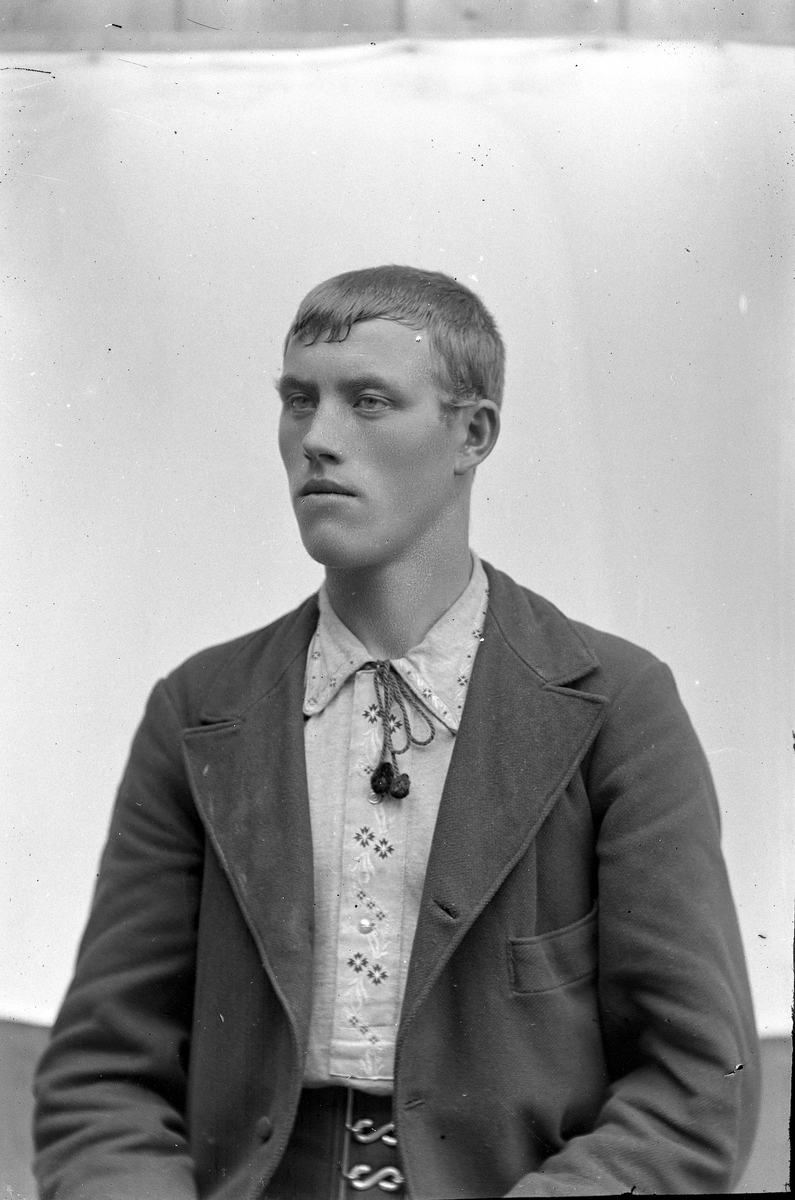 Jakob Jakobsen Engerdal, Portrett av mann m/lys skjorte med broderi på stolpe og krage. "Lisse" i halsen. Bredt belte. Svensk?