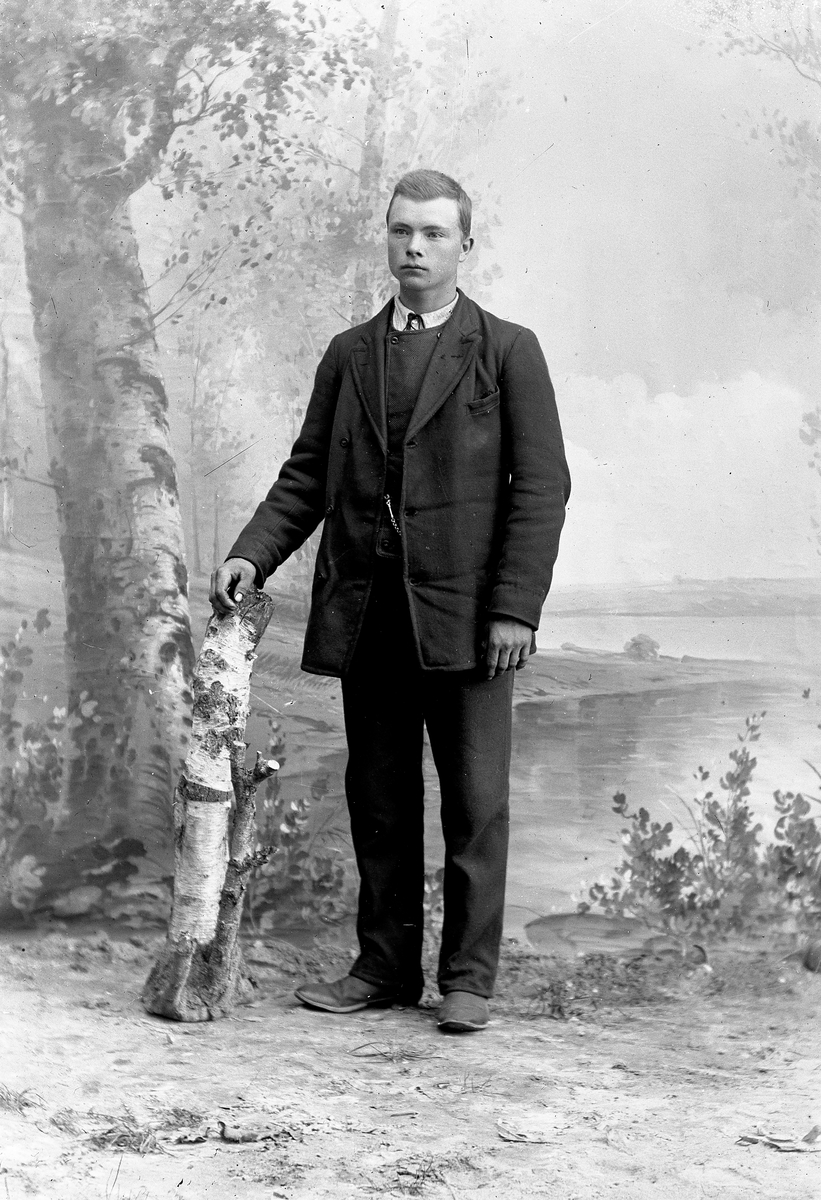 Jakob Jakobsen Engerdal, Portrett av ung mann, står ved trestubbe.