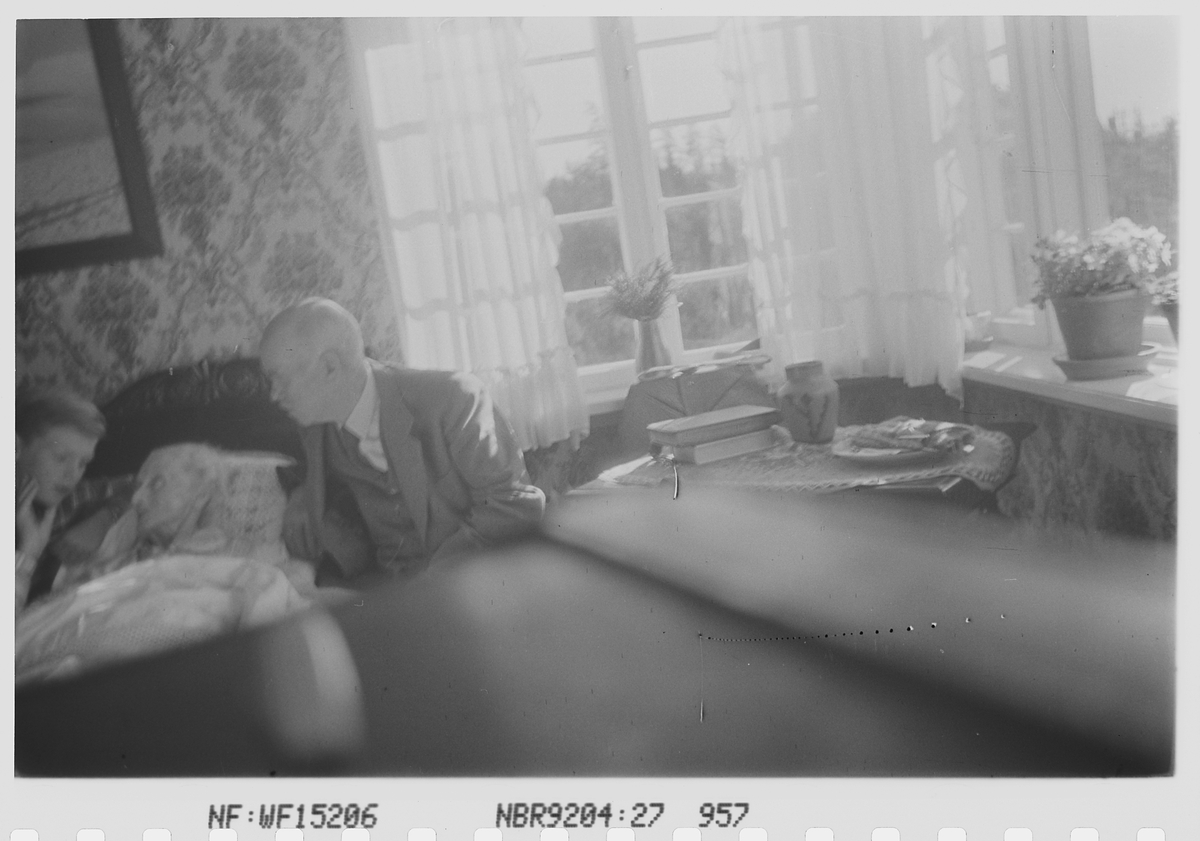 Anders Beer Wilse, Antatt Anders Beer Wilse sammen med sønnen Robert Charsel, og hustru Helen Marie Wilse født Hutchinson i sengen. Fotografi av reinsdyr på veggen. Fotografert 5.august 1941.