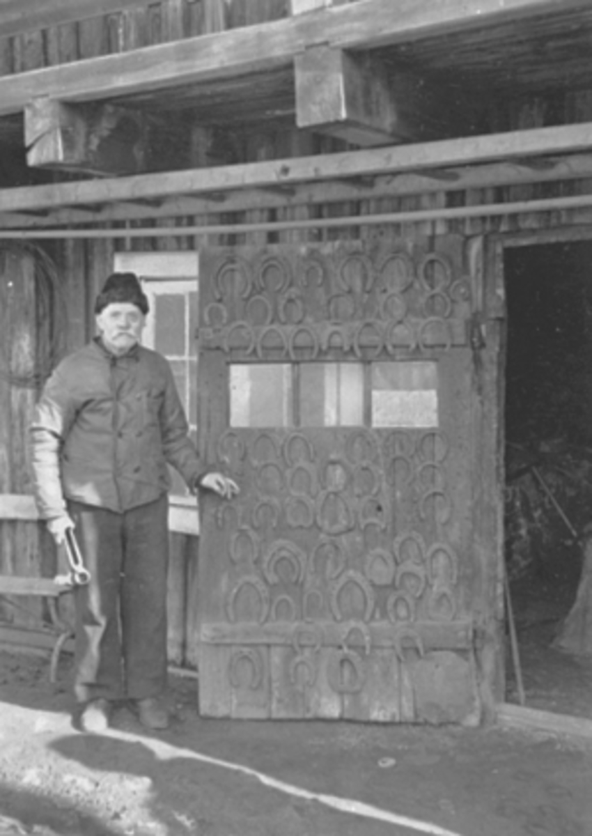 Anno Domkirkeodden, SMED ENER KORSLUND FORAN DØRA TIL SMIE, GRØNNEGATA. 104 I HAMAR, HESTSKO PÅ DØRA. KORSLUNDGÅRDEN.