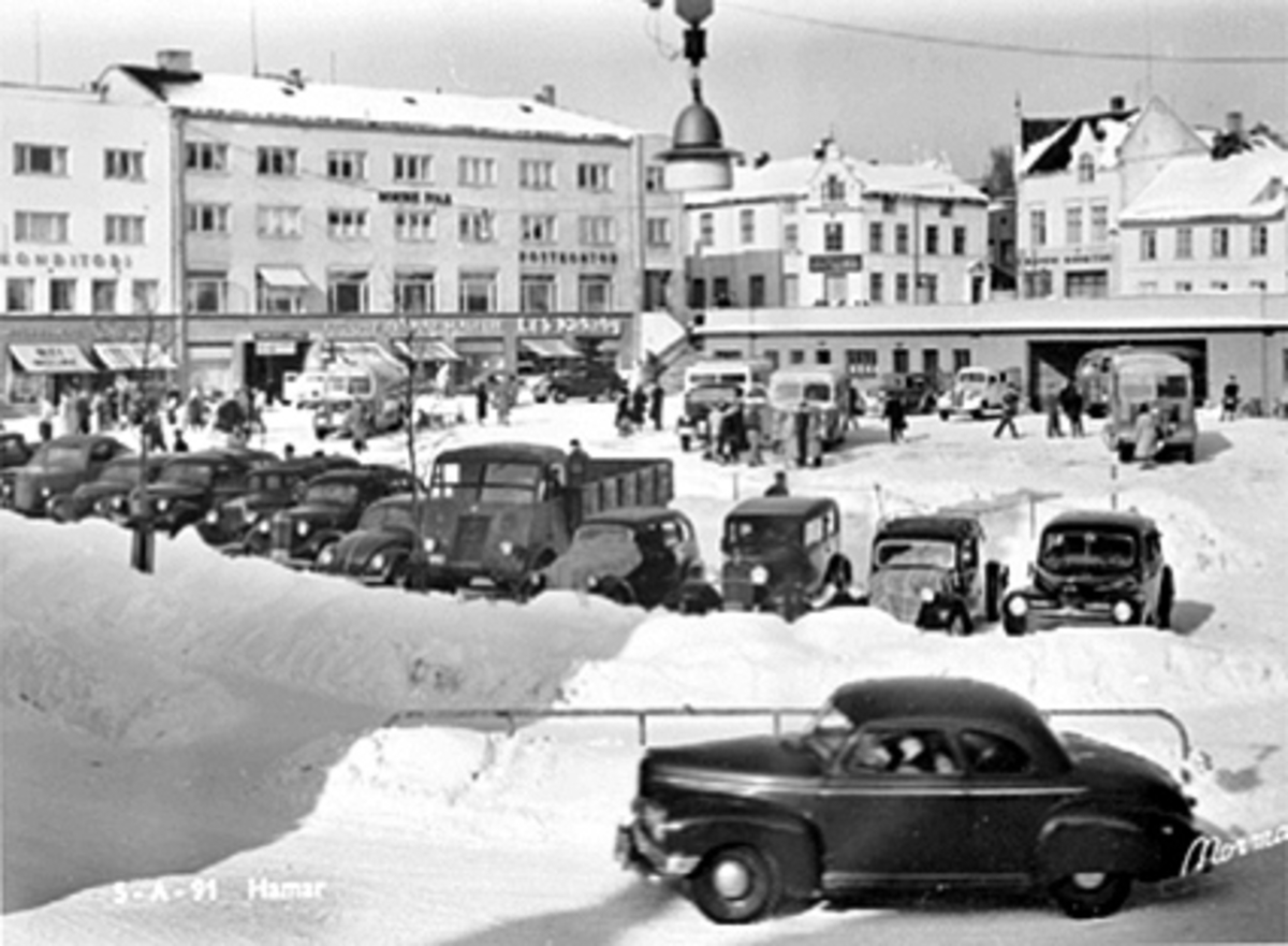 Anno Domkirkeodden, OVERSIKT ØSTRE TORG FRA KRYSSET VANGSVEGEN - TORGGATA, MANGE PARKERTE BILER, BUSSER, FOLK, VINTER, I FORGRUNNEN: 1946-47 NASH COUPE, YTTERST TIL HØYRE I REKKA BAK DEN: FORD 1946-48