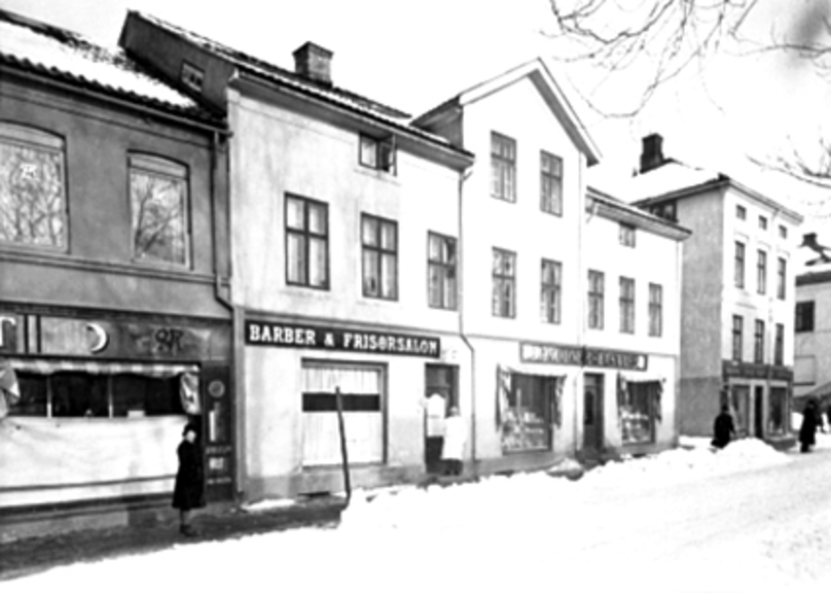 Anno Domkirkeodden, OVERSIKT TORGGATA 71 MED P. MURSTAD TIL VENSTRE, BARBER & FRISØRSALONG, LONDONERBASAREN OG SIGV. SØRENSEN TIL HØYRE, VINTER