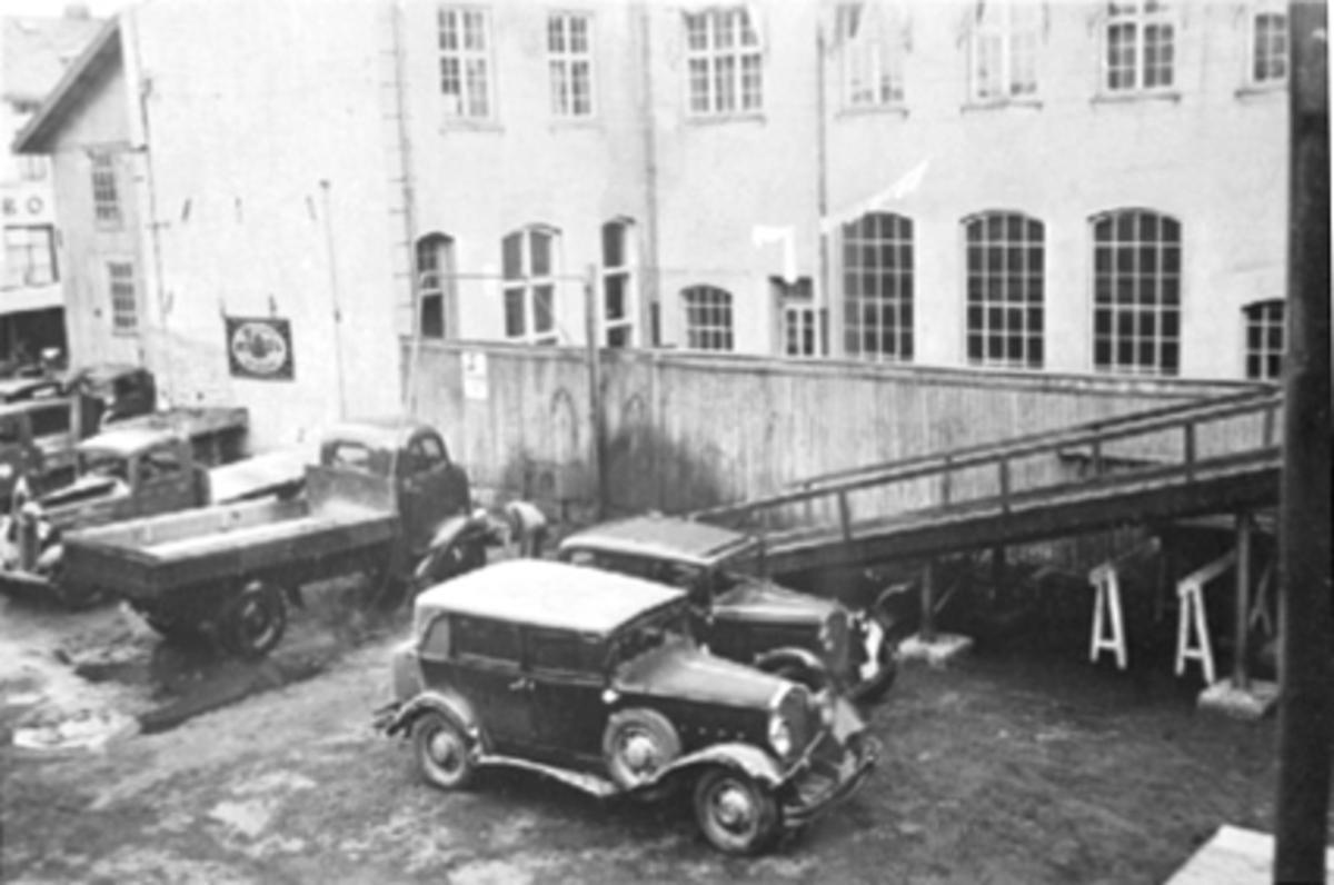 Anno Domkirkeodden, Oustad Mek. Verksted A/S, Østregate 32, Hamar. Bilverksted, bilforretning, bakgården, lastebiler, personbiler inne til service.