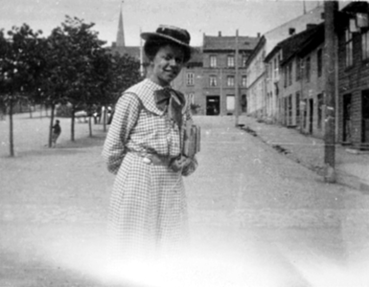 Anno Domkirkeodden, PORTRETT UNG DAME, K. GLØERSEN MED SKOLEBØKER UNDER ARMEN PÅ STORTORGET